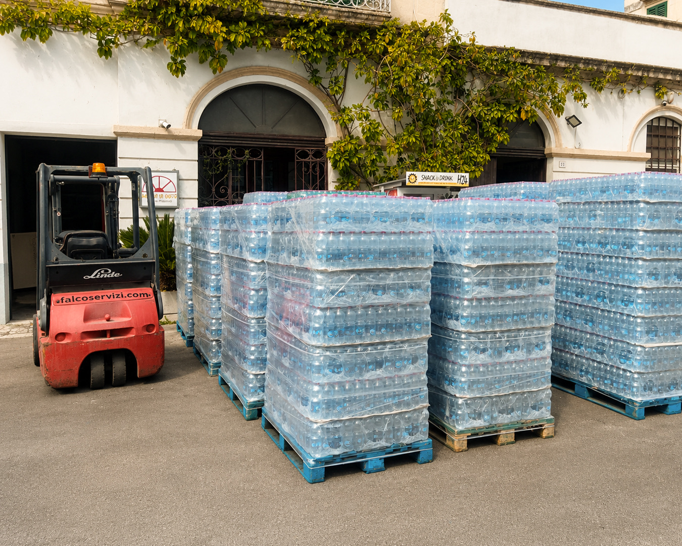 Bancali di acqua in bottiglia pronti per la consegna davanti alla sede DAM Vending a Parabita